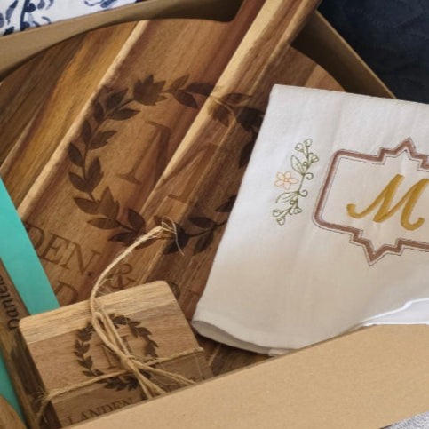 Wooden utensils and a napkin with a monogram in a box on a couch.